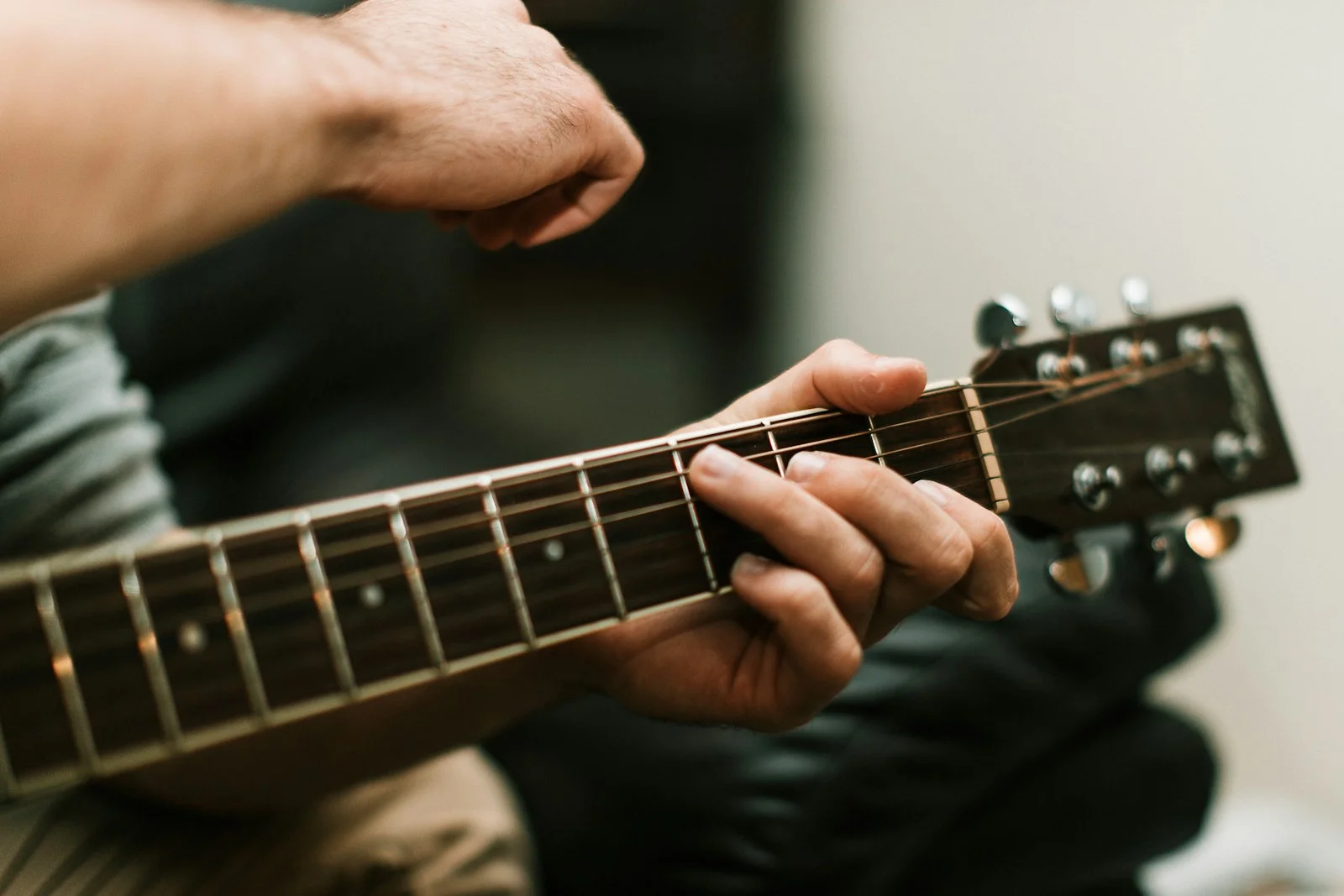 Mãos de uma pessoa tocando violão